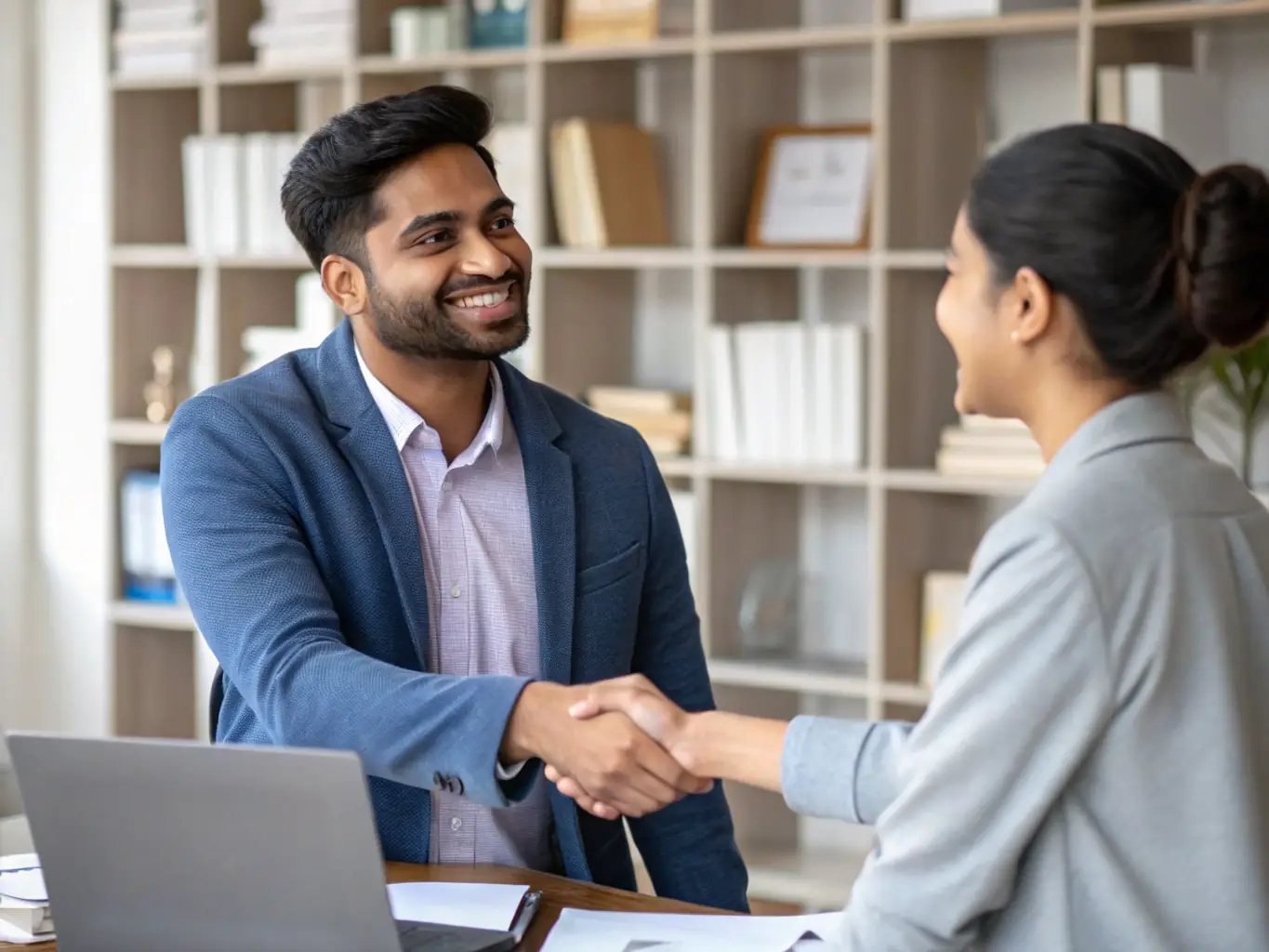 An image showcasing a successful Indian entrepreneur shaking hands with a financial consultant, representing a partnership for business funding and growth.